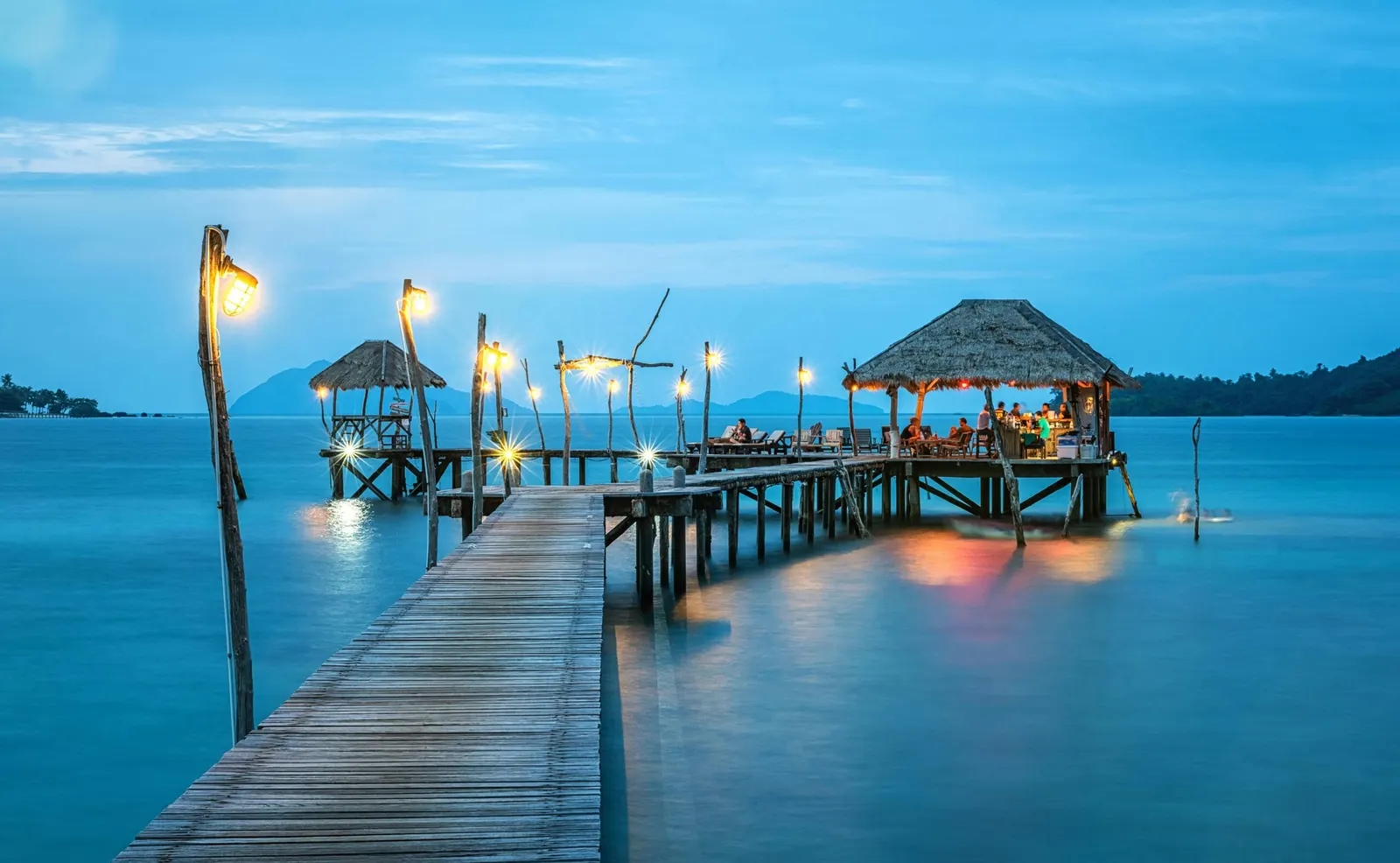 Muelle sobre aguas turquesa al atardecer